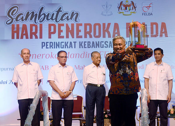 Chef Wan lifting his award that was presented to him by Prime Minister Tun Dr Mahathir (third, left) at the Felda Settlers Day celebration in Felda Selancar 3, Rompin today.