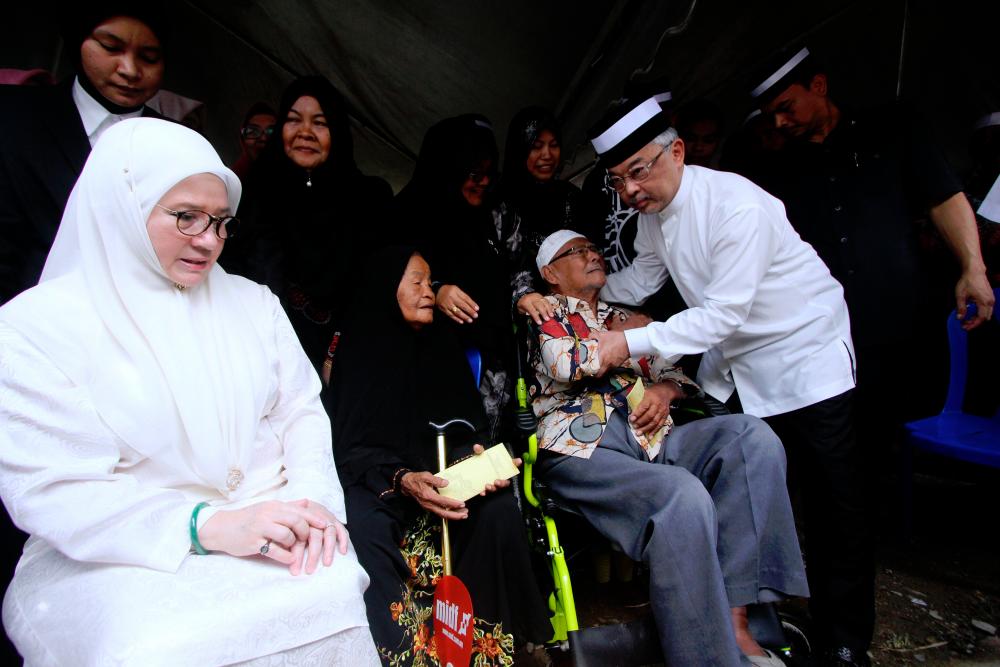Yang di-Pertuan Agong Al-Sultan Abdullah Ri’ayatuddin Al-Mustafa Billah Shah (Second from right) comforts an elder at Kampung Haji Ali today. — Bernama