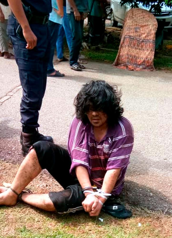 The suspected murderer after being apprehended by police. - Bernama