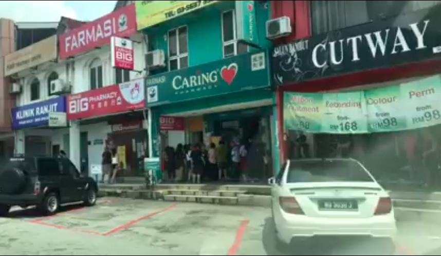 Screenshot from the video shows people lining up in front of a pharmacy in Subang Jaya.