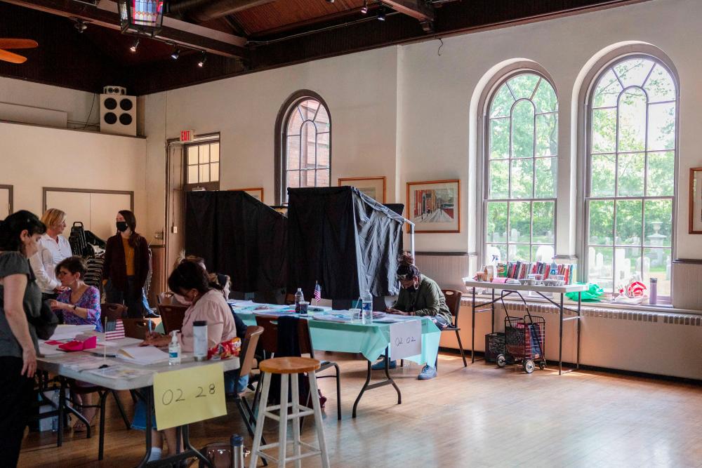 A poll worker signs in a voter for the Pennsylvania primary elections, at a polling place in the Gloria Dei Old Swedes Episcopal Church in Philadelphia, Pennsylvania, U.S., May 17, 2022. REUTERSpix