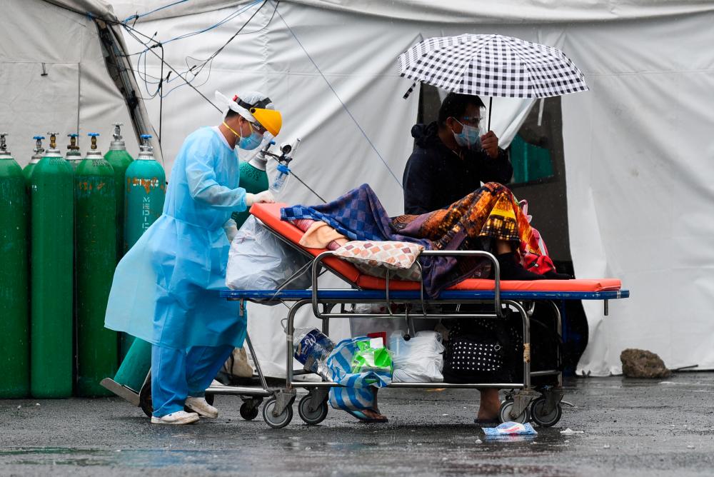 FILE PHOTO: A health worker wearing personal protective equipment (PPE) as protection against the coronarivus disease (Covid-19) transports a suspected Covid-19 patient, at Sta. Ana Hospital, in Manila, Philippines, September 8, 2021. REUTERSpix