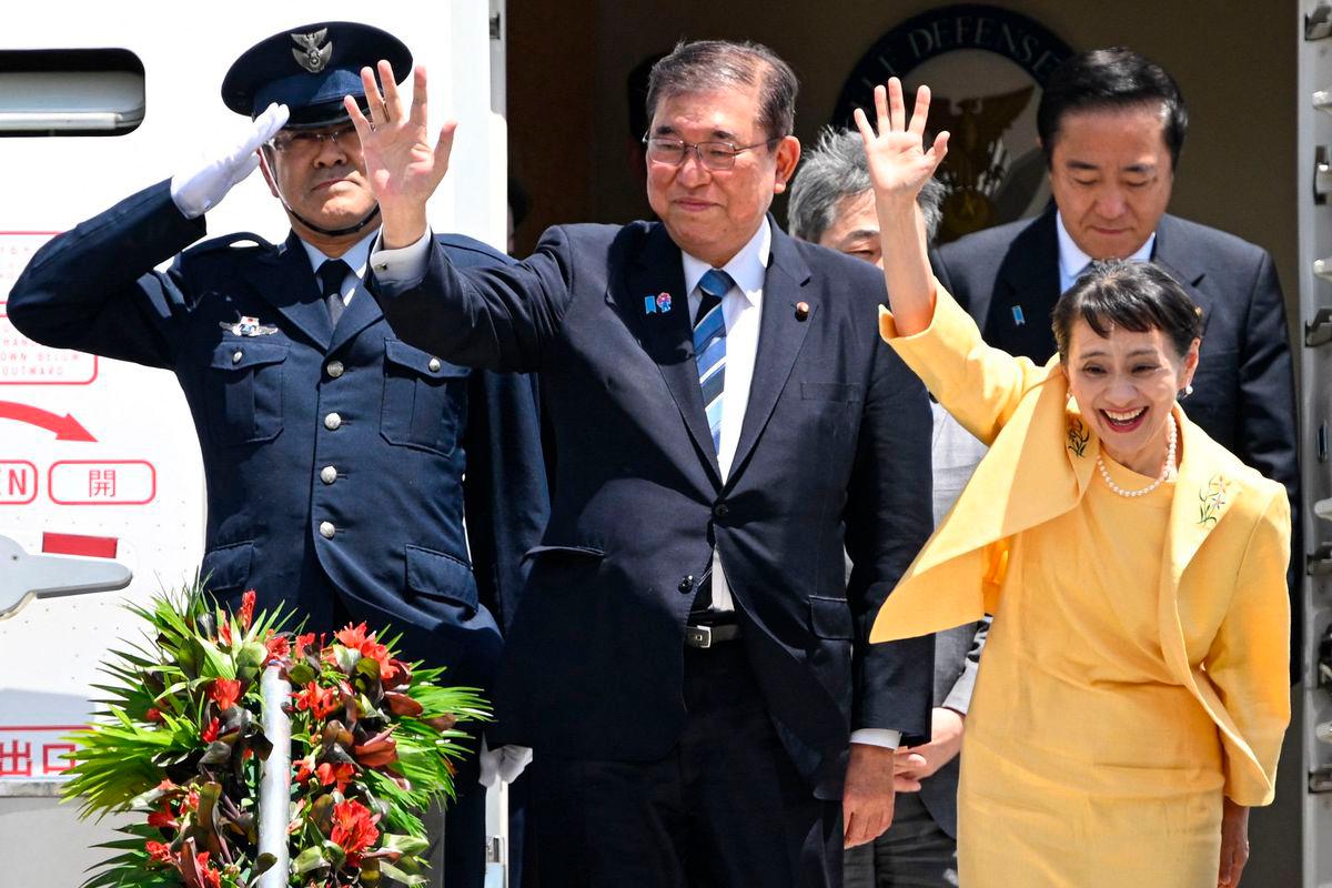 Japan’s Prime Minister Shigeru Ishiba (2nd L) and his wife Yoshiko Ishiba (R) wave as they disembark the plane upon their arrival at the Ninoy Aquino International Airport in Manila on April 29, 2025. (Photo by TED ALJIBE / AFP)