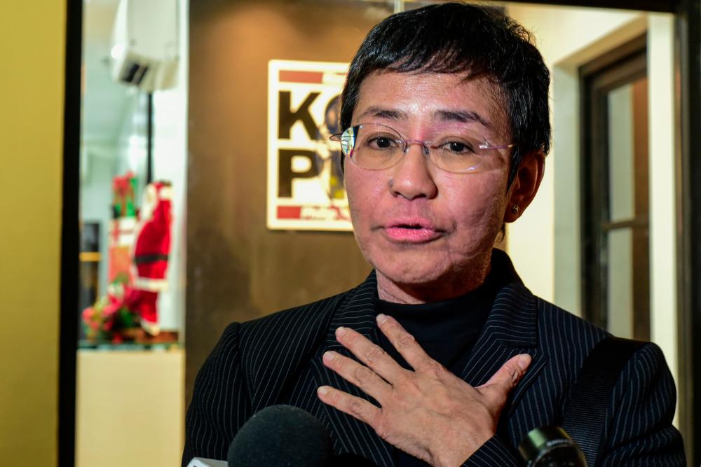 Maria Ressa, co-founder and CEO of the Philippines-based news website Rappler, speaks to members of the media as she leaves after a hearing in a court in Manila on Dec 16. — AFP