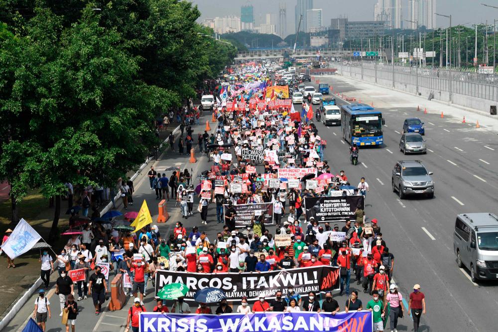 Protesters march during a rally to coincide with Philippine President Ferdinand Marcos Jr's first State of the Nation address, in Quezon City. – AFPPIX