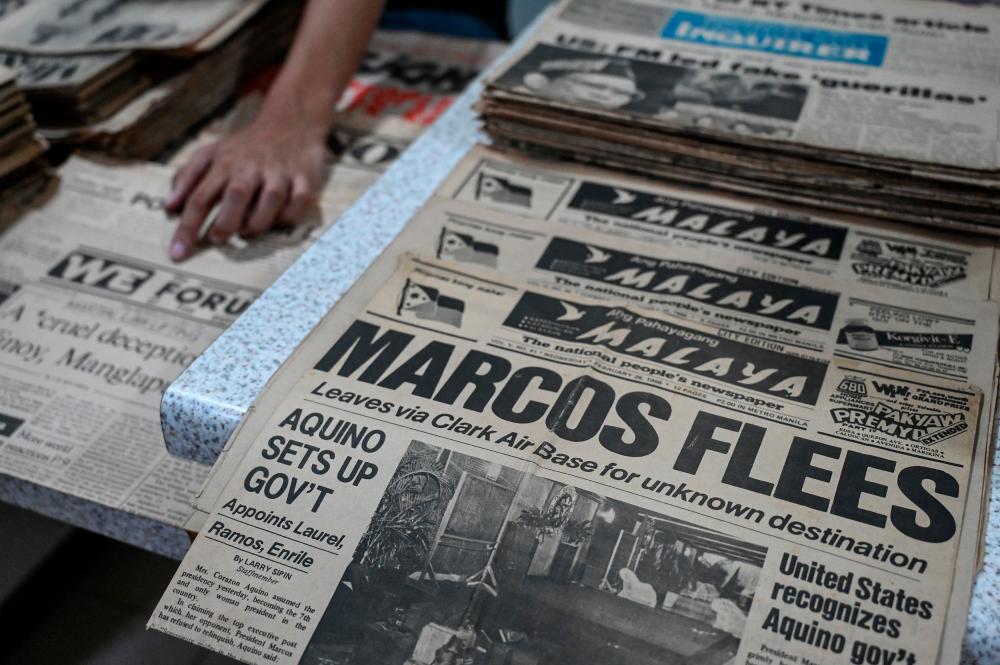 This photo taken on September 3, 2022 shows copies of the Philippine newspaper Ang Pahayagang Malaya dated February 26, 1986 with the headline of then-dictator Ferdinand Marcos Sr. fleeing the country, among other period publications to be archived, in Taguig, suburban Manila. - AFPPIX