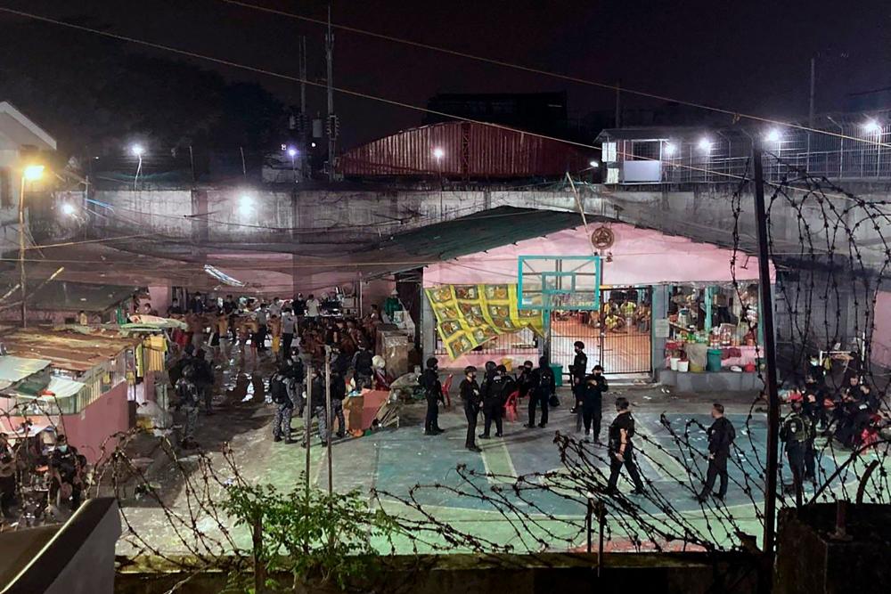 Members of the police Special Weapons and Tactics (SWAT) team guarding the premises after a deadly brawl between rival gangs that killed six and wounded 33 at Caloocan City Jail, suburban Manila. AFPPIX