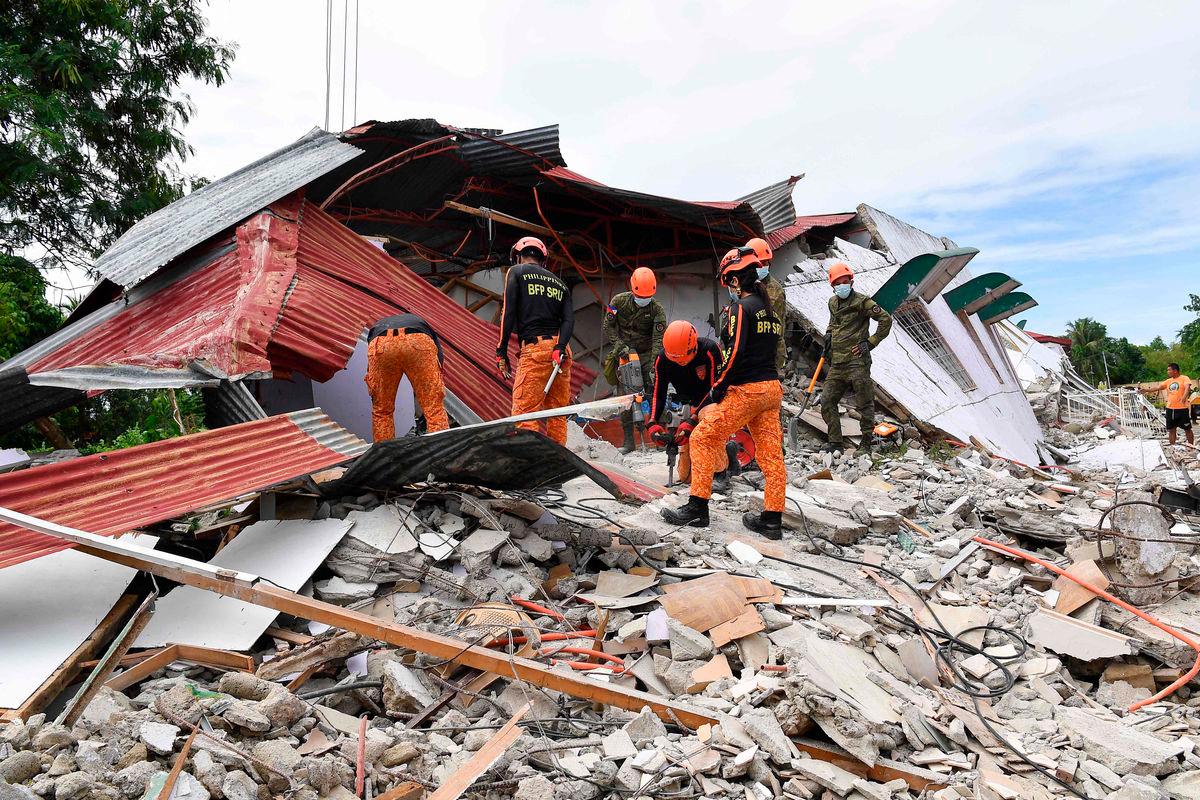 Rescuers search for three people who were reported missing under the rubble of a collapsed building in Bogo City on October 1, 2025. (Photo by TED ALJIBE / AFP)