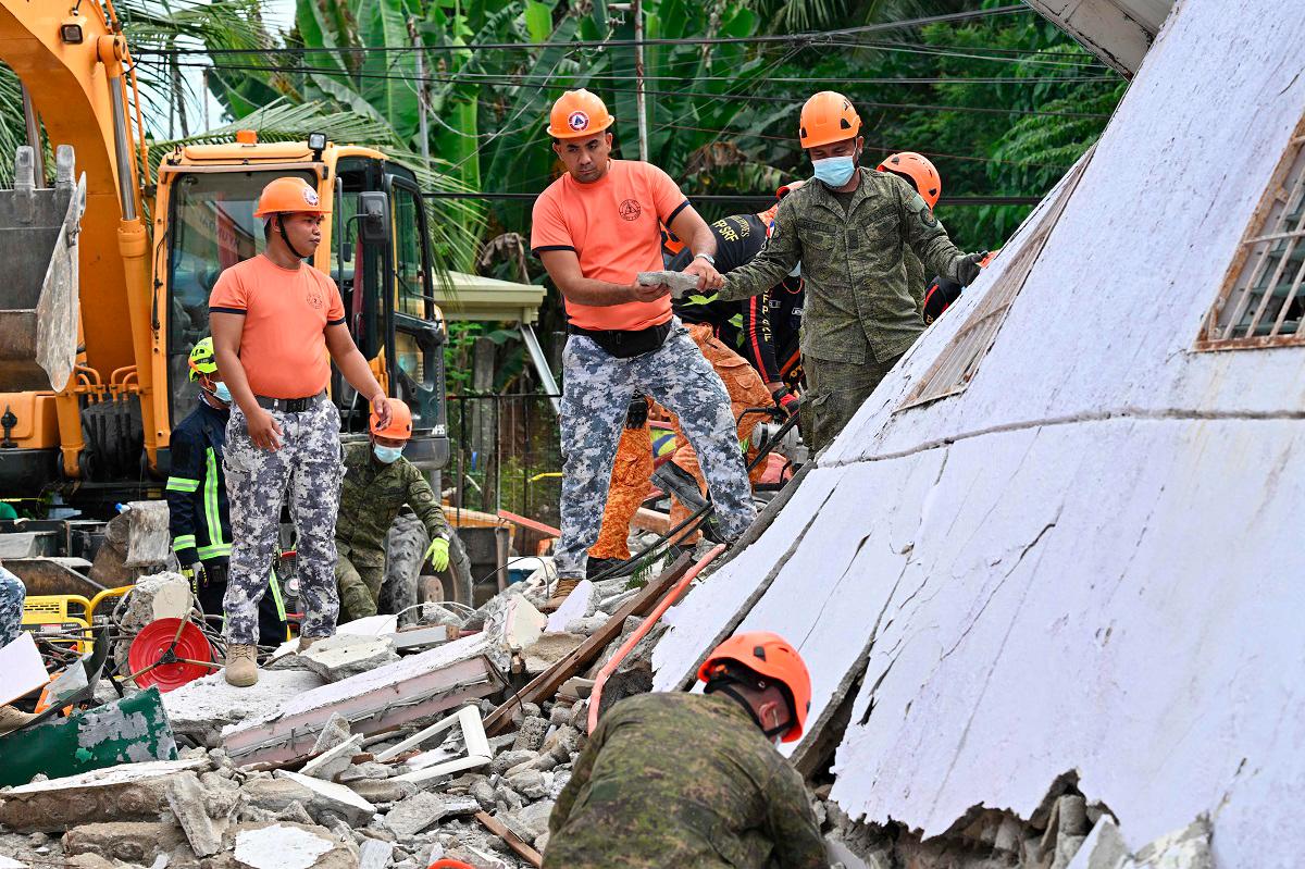 Rescuers clear rubble during search and rescue operations in Bogo City on October 1, 2025, after a 6.9-magnitude quake struck off the coast of the central Philippines late September 30. - Ted ALJIBE / AFP