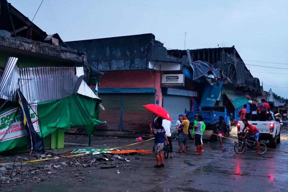 Residents look at a destroyed building after a 6.8- magnitude earthquake in the town of Padada in Davao del Sur province on the southern island of Mindanao. - AFP
