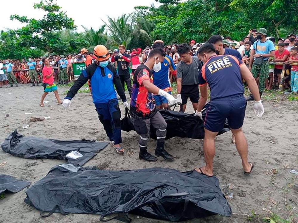Rescuers carry a body bag containing the dead body of a victim of a landslide that slammed the village of Pilar in Abuyog town, Leyte province on April 13, 2022, days after heavy rains inundated the town brought about by Tropical Storm Megi. AFPPIX