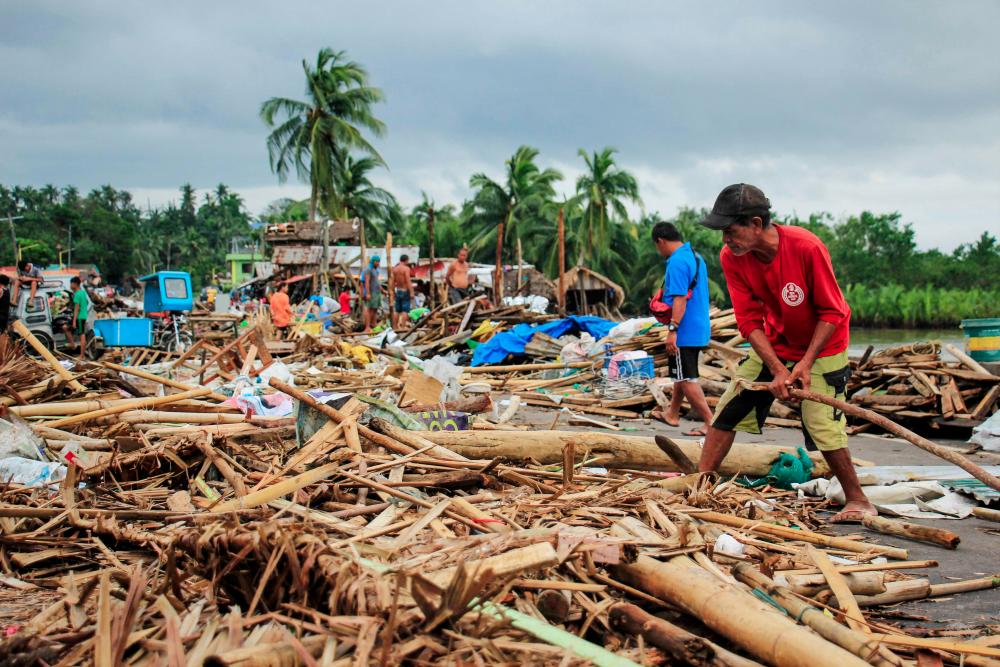 Residents gather debris from their destroyed houses after typhoon Kammuri hit the city of Sorsogon, south of of Manila on Dec 3, 2019. — AFP