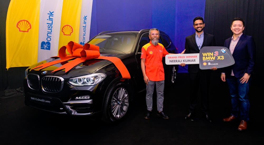 Shairan (left) and BonusKad Loyalty Sdn Bhd CEO Melvin Ooi (right) presenting the BMW X3 to Neeraj yesterday.