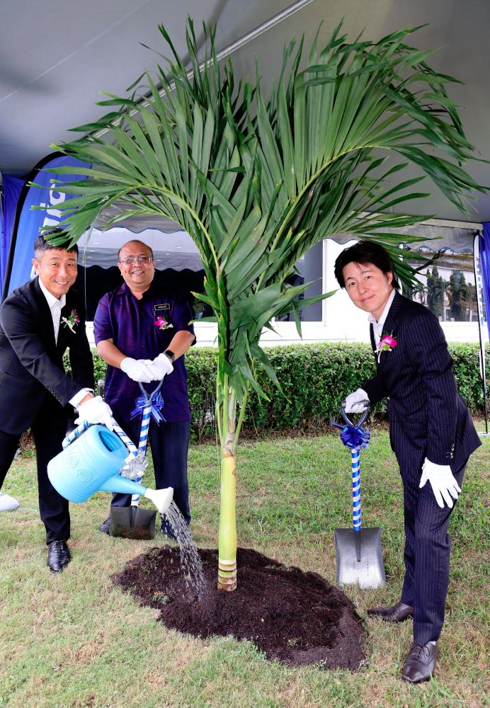 From left - Panasonic Automotive Systems Malaysia managing director Takahiro Suzuki, Penang State Department of Environment director Norazizi Adinan, and Panasonic Automotive Systems Corporation executive officer Takayuki Tanabe planting a tree at the factory.