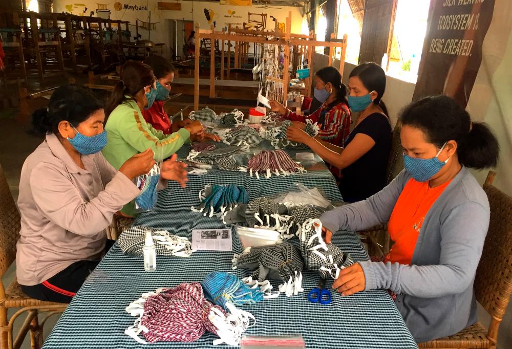 Weavers from the Maybank Women Eco-Weavers programme in Cambodia packing the finished handwoven masks to be shipped out for distribution.