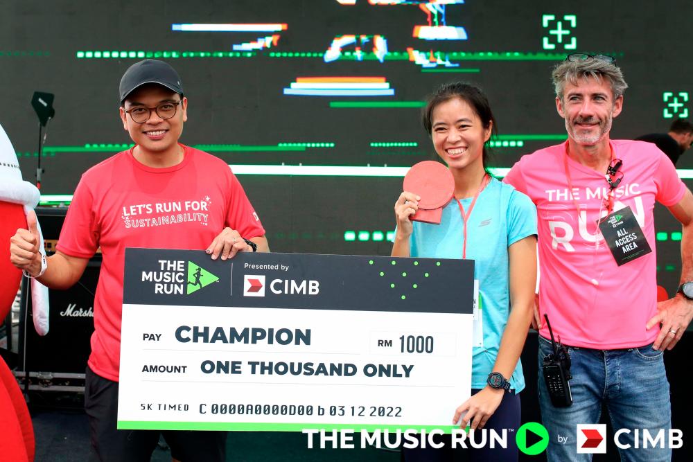 $!The 5KM Timed Run women’s category winner, Penny Loh, received her prize from (left) CIMB Group CFO, Khairul Rifaie and (right) Fresh Event Asia General Manager, Jeffrey Ross. – Photo courtesy of The Music Run