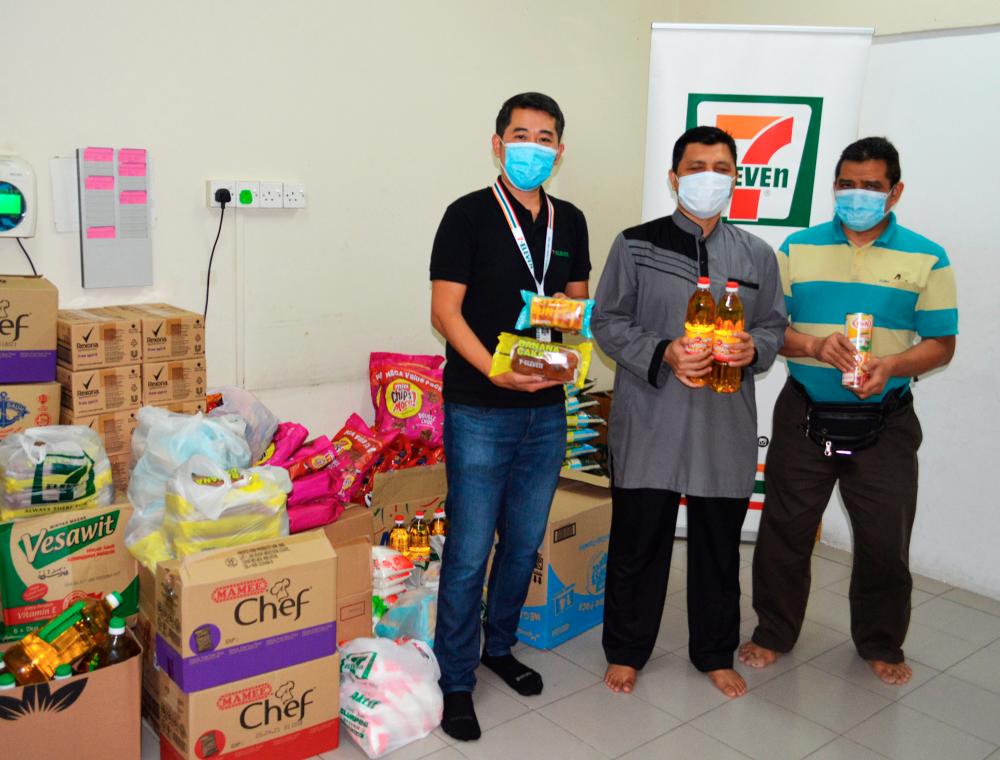 7-Eleven Malaysia Marketing General Manager Ronan Lee (left) handing over food supplies to representatives of Persatuan Orang-Orang Cacat Penglihatan Islam Malaysia (PERTIS).
