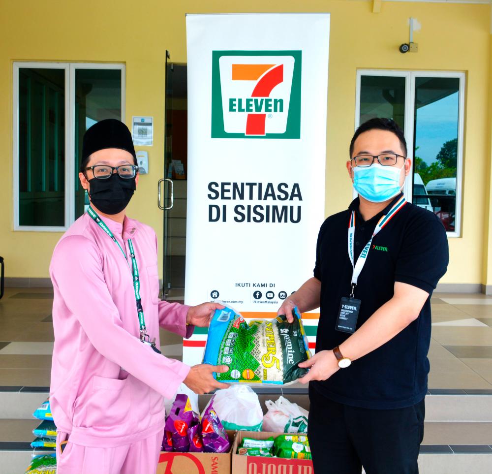 Rumah Aman Children’s Home Manager, Abang Arizuan Abang Arabi (left) receiving aid from 7-Eleven Malaysia’s representative.