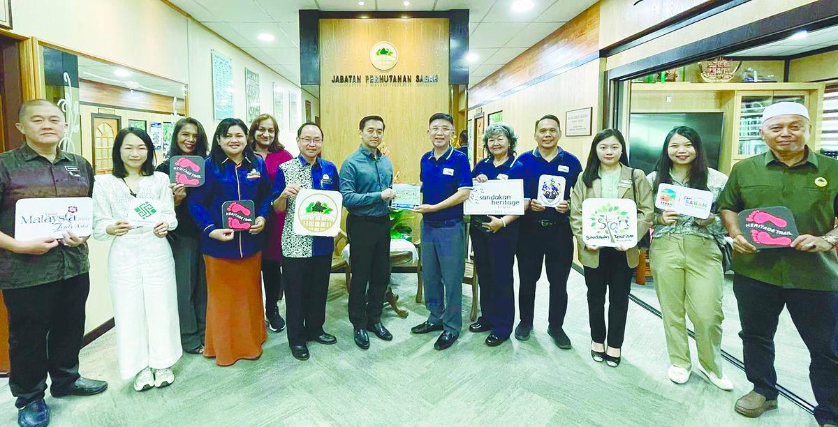 Lai (sixth from right) presents a memento to Kugan during the courtesy call.
