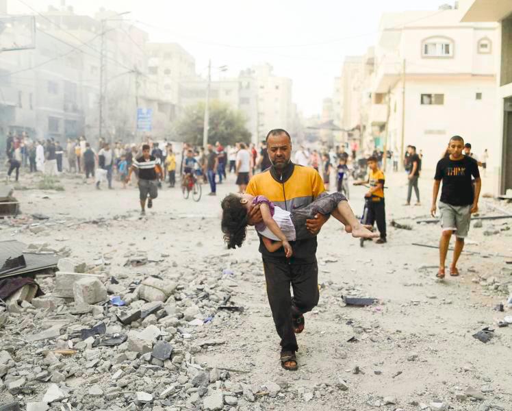 A Palestinian carries a wounded girl at the site of Israeli strikes, in Khan Younis in the southern Gaza Strip. – REUTERSPIC