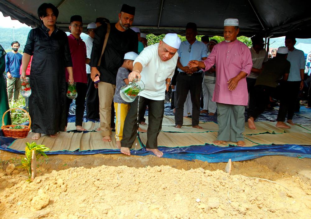 LENGGONG, Jan 11 -- Perak Menteri Besar Datuk Seri Saarani Mohamad sprinkled rose water at the grave of his mother, the late Aminah Mohd Yusuf, after she was safely buried at Kampung Raban Cemetery today. BERNAMAPIX