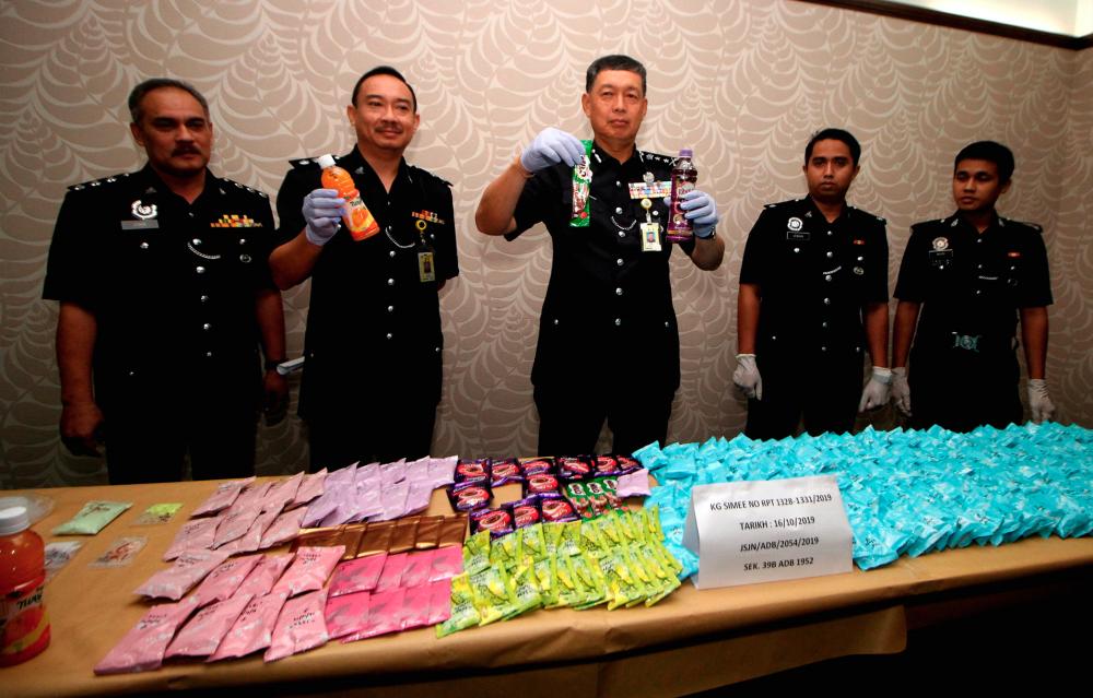 Perak deputy police chief Datuk Lim Hong Shuan (C) along with police personnel display the total of RM753,295 worth of drugs seized, at a press conference at the Perak contingent police headquarters today. - Bernama