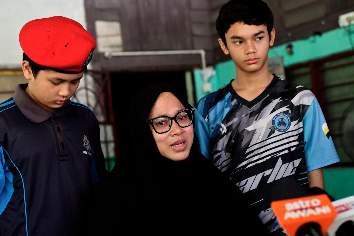 The wife of the late Corporal Amiruddin Zabri, Norazian Mohd Joned, 38, (centre), along with her sons Amirul Firdaus Amiruddin, 12, (left), and Amirul Asyraf Amiruddin, 11, was met by the media during the National Higher Education Fund Corporation (PTPTN)’s Ziarah Kasih programme in Kampung Sungai Itik today. - BERNAMApix