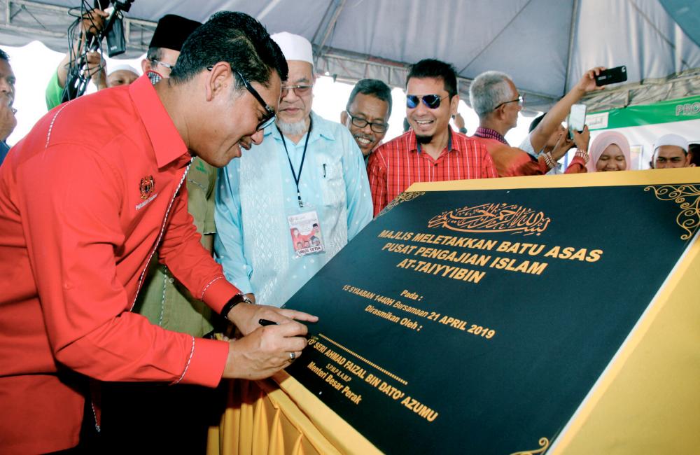 Perak Mentri Besar Datuk Seri Ahmad Faizal Azumu (L) signs the plaque during the occasion of the placement of the foundation stone for the At-Taiyyibin Islamic Studies Centre in Kampung Tersusun, Tanah Hitam, Chemor, on April 21, 2019. — Bernama