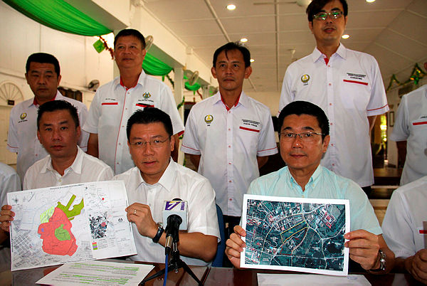 Teluk Intan MP and Deputy Speaker Nga Kor Ming (seated C) and Taiping MP Lim Lim (seated R) show land plans that have been issued for the Taiping Lake Gardens for commercial development purposes at a press conference. — Bernama