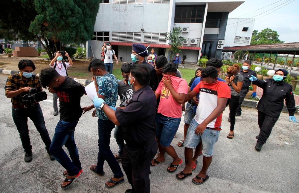 Fifteen individuals who violated the movement control order, are led to the Ipoh magistrate’s court, on March 4, 2020. — Bernama
