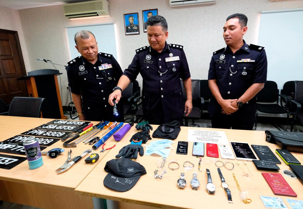 Ipoh district police chief ACP A. Asmadi Abdul Aziz displays the items seized from the Ah Leong gang at a press conference at the Ipoh district police headquarters, today. - Bernama