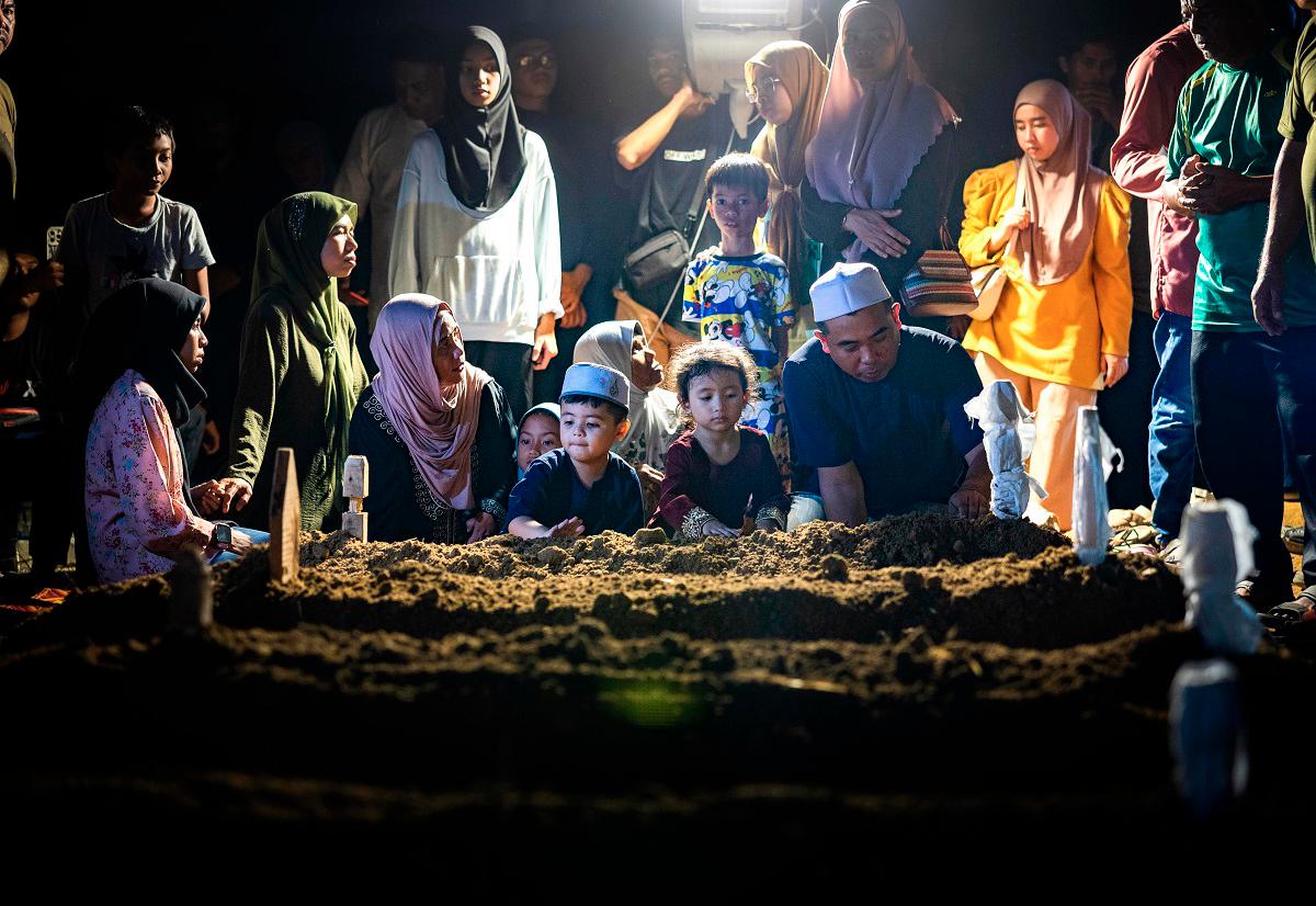 Waris mangsa kemalangan membabitkan dua kenderaan di Kilometer 7, Jalan Jerantut-Maran, Pahang, semalam, hadir pada pengebumian jenazah keluarga masing-masing di Tanah Perkuburan Islam Kampung Selat, Bota Kanan, awal pagi ini. - Bernama