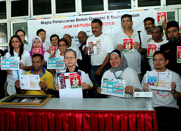 Deputy Health Minister Dr Lee Boon Chye (sitting, 2nd from L) holds up a pamphlet at the anti-aedes campaign organised by Ipoh Selatan Rotary Club at the Greentown Health Clinic in Ipoh on Feb 24, 2019. — Bernama