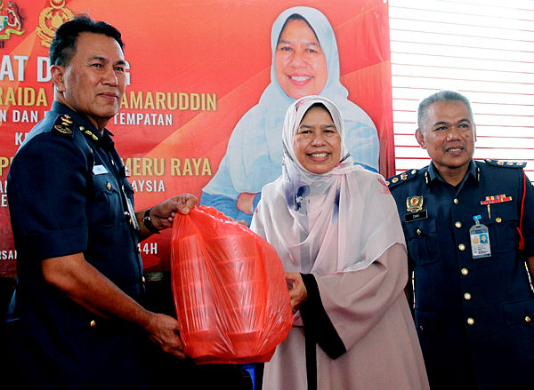 Minister of Housing and Local Government Zuraida Kamaruddin hands over a donation to JBPM Perak director Azmi Osman, to be distributed to JBPM Perak employees at Balai Bomba Meru Raya, Ipoh on May 12, 2019. — Bernama