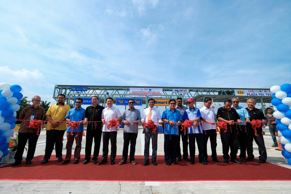 Deputy Works Minister Mohd Anuar Mohd Tahir (centre) officiates the opening of the Section 8 stretch, Hutan Melintang-Teluk Intan, of WCE at the Teluk Intan toll plaza. The range will be officially opened to the public at 6pm today. - Bernama