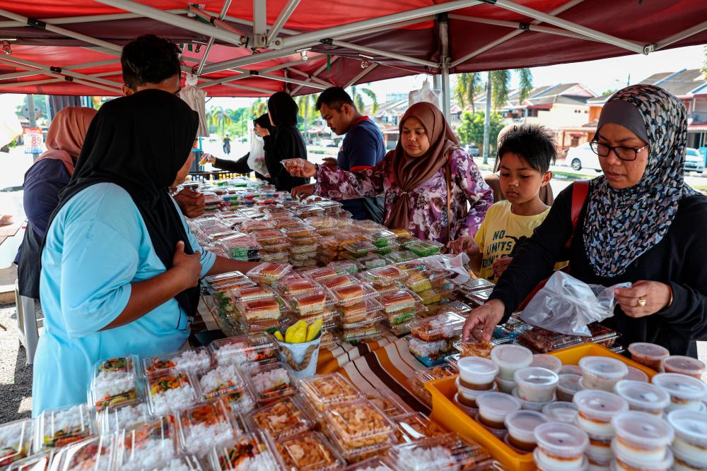 IPOH, March 25 -- Customers bought a variety of confectionary cakes sold at RM1 per packet at a stall in Taman Klebang Restu, yesterday. BERNAMAPIX