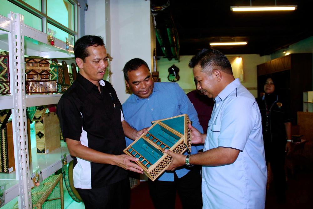 Taiping Prison director Charin Promwhichit (R) shows a handicraft made by a prisoner to Taiping Police director ACP Osman Mamat (C) after the officiation of the Prison Handicraft Gallery at Bukit Merah Laketown Resort near Bagan Serai on May 5, 2019. — Bernama