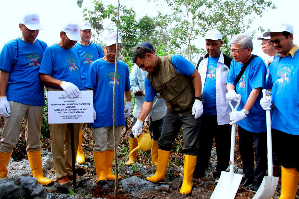 Domestic Trade and Consumer Affairs Minister, Datuk Seri Saifuddin Nasution Ismail (4thL), waters a plant during Aeon Malaysia’s 35th anniversary at the Bidor Research Station, Forest Research Institute of Malaysia (FRIM), on Sept 14, 2019. — Bernama