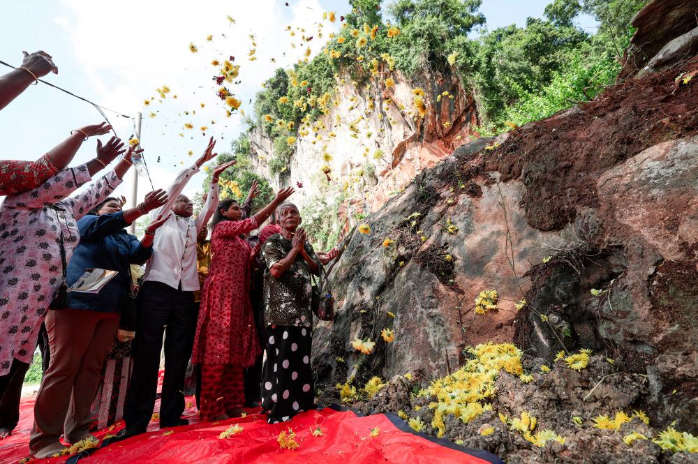 Pengerusi Jawatankuasa Sumber Manusia, Kesihatan, Hal Ehwal Masyarakat India dan Integrasi Perak A.Sivanesan (tiga, kiri) bersama waris mangsa runtuhan melempar bunga di batu yang runtuh dari Gunung Cheroh pada Majlis Pengkisahan Sejarah Runtuhan Gunung Cheroh - 50 Tahun Dalam Ingatan di pekarangan gunung itu pada Okt 24 2023. - fotoBERNAMA