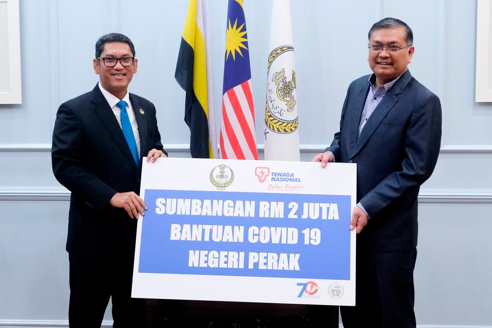 Perak Mentri Besar Datuk Seri Ahmad Faizal Azumu (L) receives donation from Tenaga Nasional Berhad (TNB) presented by Energy and Natural Resources Minister Datuk Dr Shamsul Anuar Nasarah. - Bernama