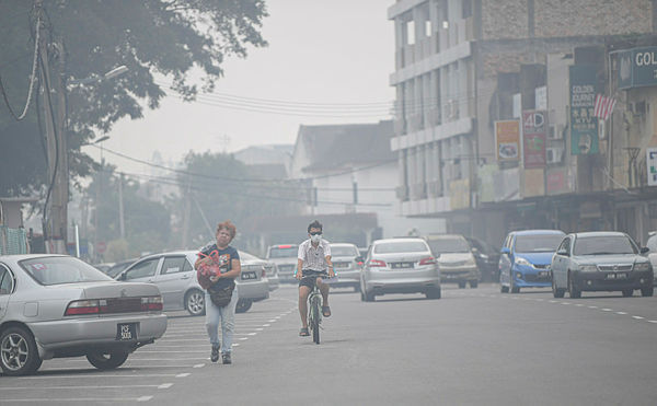 A view of residents dealing with the haze at 5pm in Seri Manjung yesterday. — Bernama