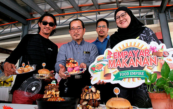 Deputy Director of Perak Fama Idris Tahir (two, left) presenting the varieties of food that will be sold during the FamaFest, today. — Bernama