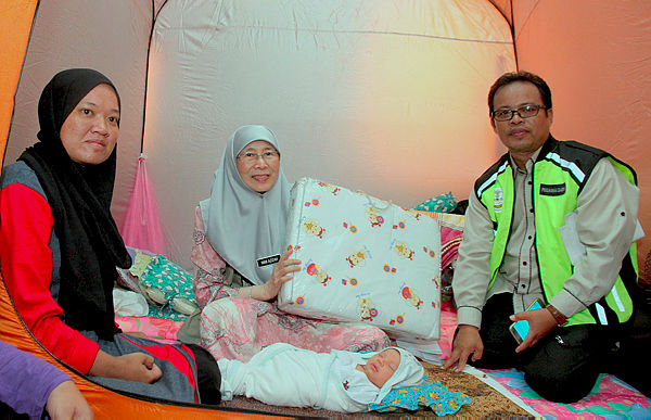 Deputy Prime Minister Datuk Seri Dr Wan Azizah Wan Ismail (center) with flood victims at the flood evacuation centre at Sekolah Kebangsaan (SK) Changkat Lobak, today. — Bernama