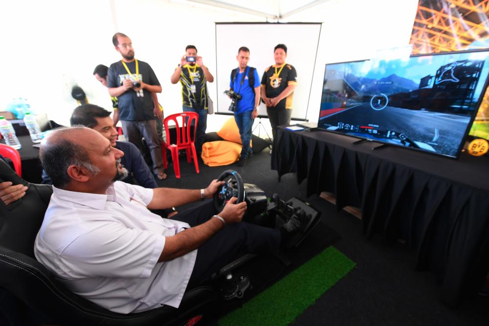 Communications and Multimedia Minister Gobind Singh Deo tries a virtual reality (VR) adventure game, while visiting an exhibition in conjunction with the launch of the Kembara Digital Malaysia at the Sultan Azlan Shah Circle, Meru today. - Bernama
