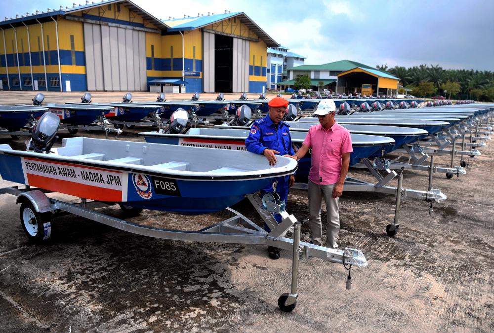 APM deputy chief commissioner (Management), Sukiman Ahmad (L) examines a fibre glass boat undergoing final acceptance test for use in times of disaster at the Malaysian Institute of Marine Engineering Technology, Setiawan on Dec 6, 2018. — Bernama