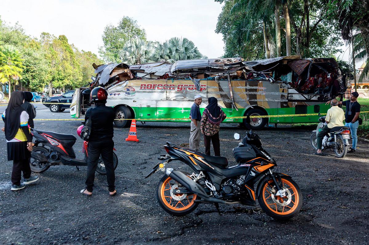 People looking at the condition of the bus involved in the horrific accident that claimed the lives of 15 individuals, early yesterday morning in front of the Gerik district police headquarters today. - Bernama pic
