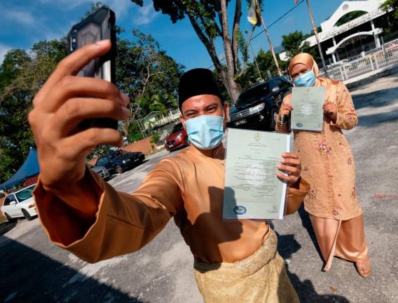 A couple celebrates their marriage solemnisation ceremony in Perak on April 22, 2020. Pahang will now allow such ceremonies to be held during the MCO. - Bernama