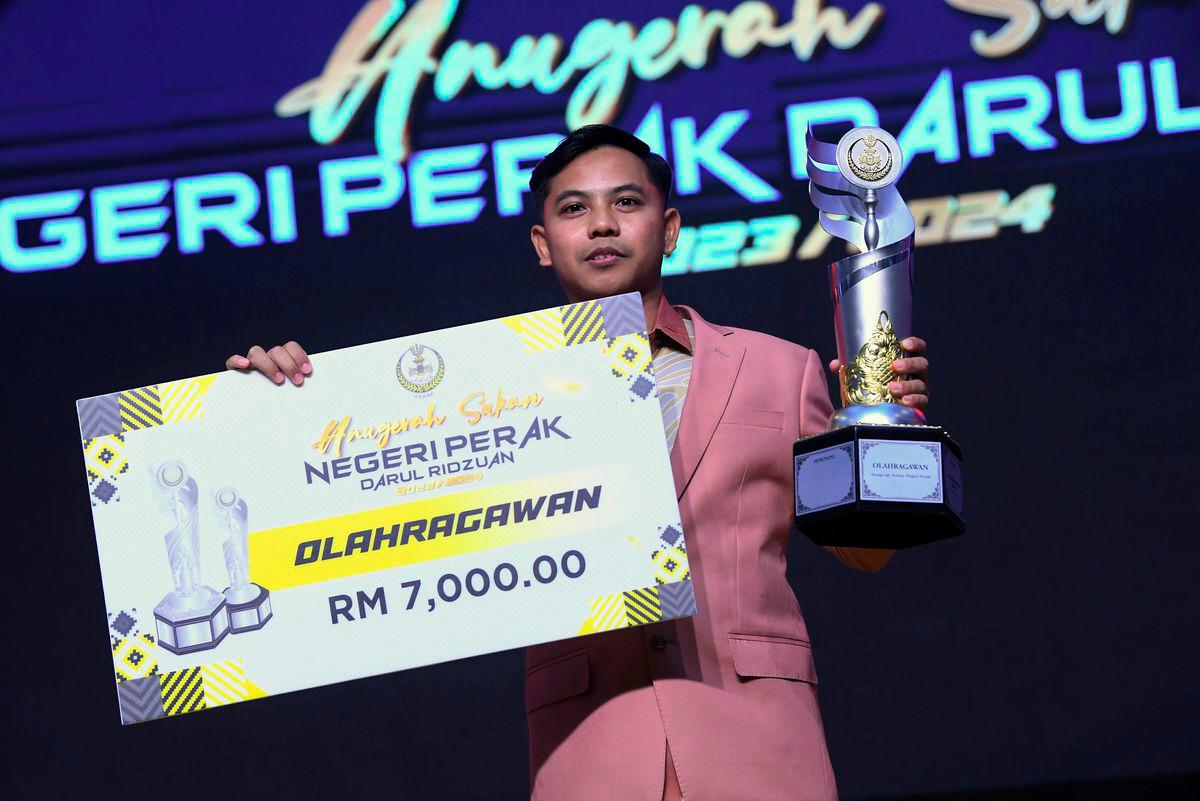 Olahragawan Izzat Shameer Dzulkeple bergambar bersama piala dan replika cek pada Majlis Anugerah Sukan Negeri Perak Darul Ridzuan 2023/2024, semalam- BERNAMA