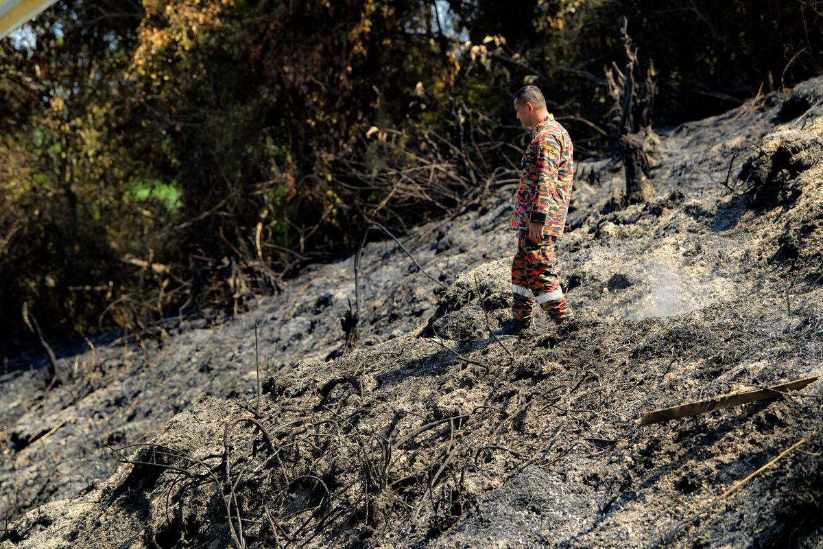 Anggota Bomba dan Penyelamat Zon 2 Negeri Perak melakukan pemantauan kawasan kebakaran hutan belukar yang terjejas seluas 23.47 hektar di Kampung Tersusun Tebuk Panchor, Gunung Semanggol hari ini. - fotoBERNAMA