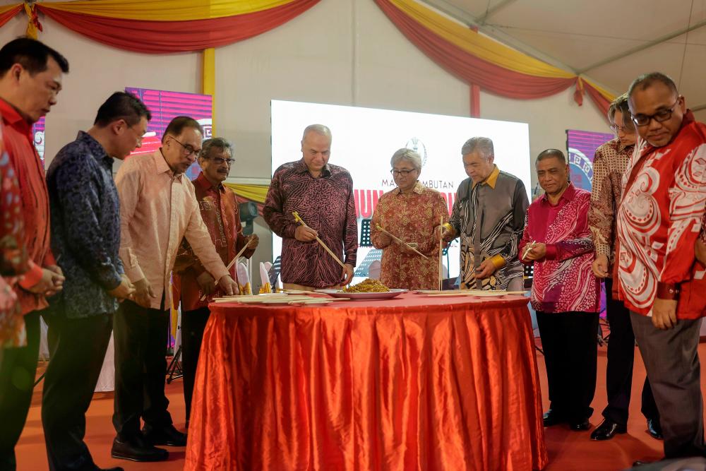 IPOH, 29 Jan -- Sultan Perak Sultan Nazrin Shah berkenan menggaul ‘Yee Sang’ bersama Perdana Menteri Datuk Seri Anwar Ibrahim (tiga, kiri) pada Majlis Rumah Terbuka Tahun Baharu Cina Peringkat Negeri Perak di Taman Tema Lost World of Tambun hari ini. fotoBERNAMA